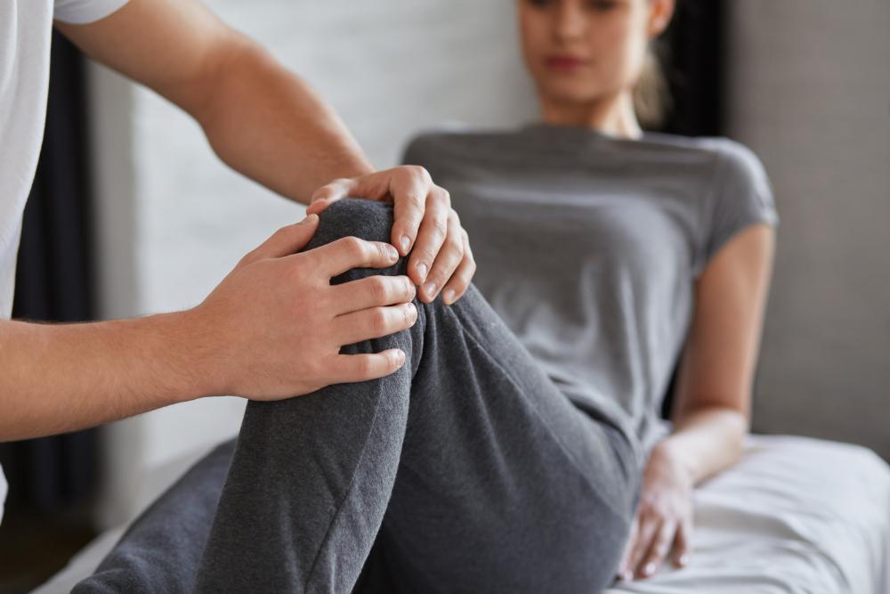 Osteópata revisando la rodilla de una mujer